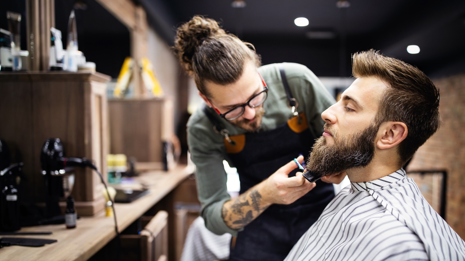 Barber trimming a man's beard
